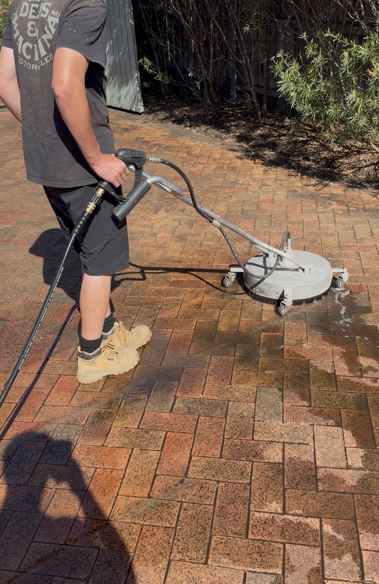 Surface cleaner on paver driveway showing before and after difference