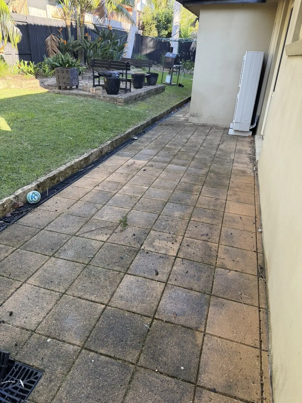 Terracotta paver patio dark with grime and mould before cleaning
