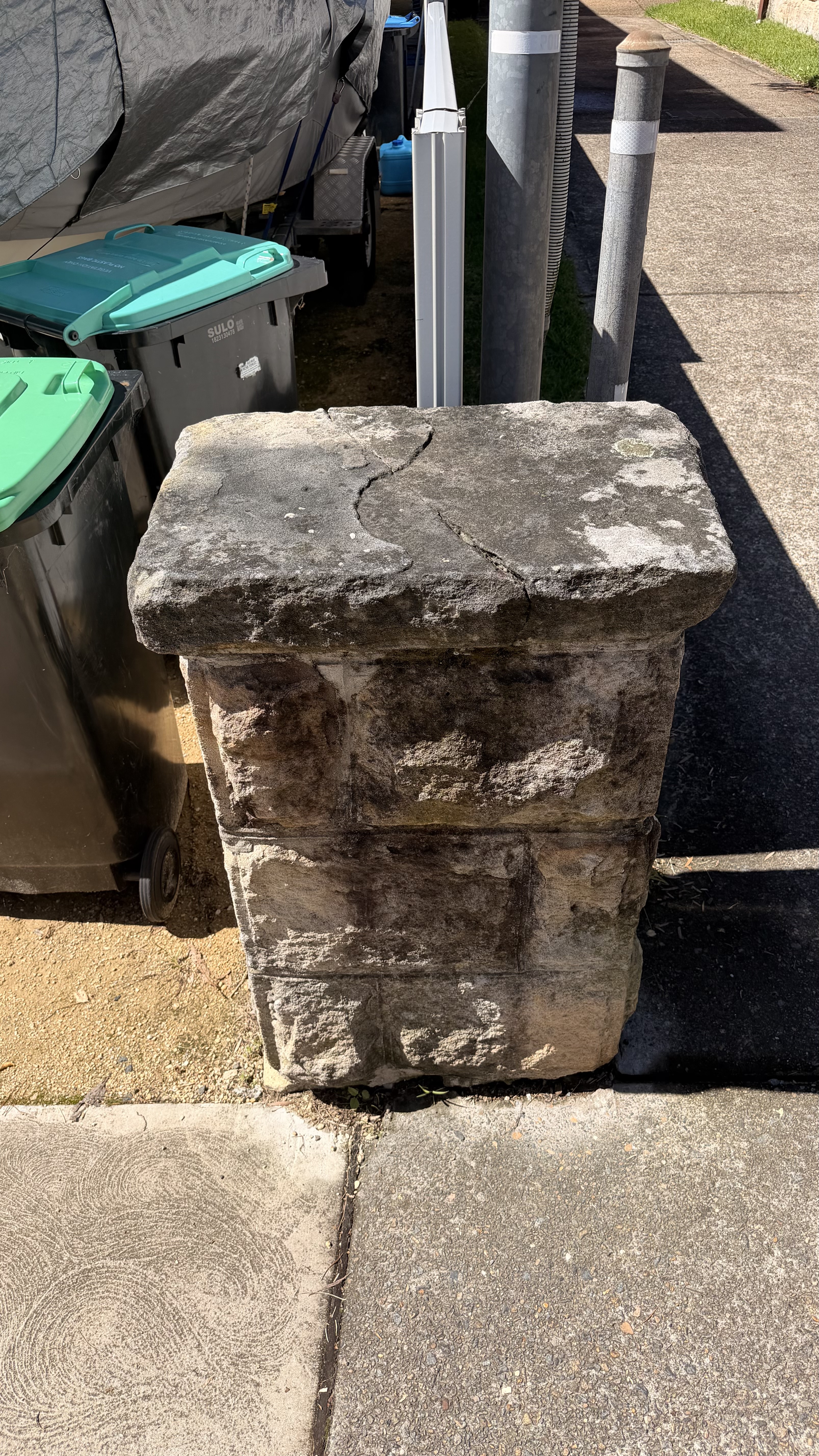 Sandstone pillar covered in dirt and mould before cleaning