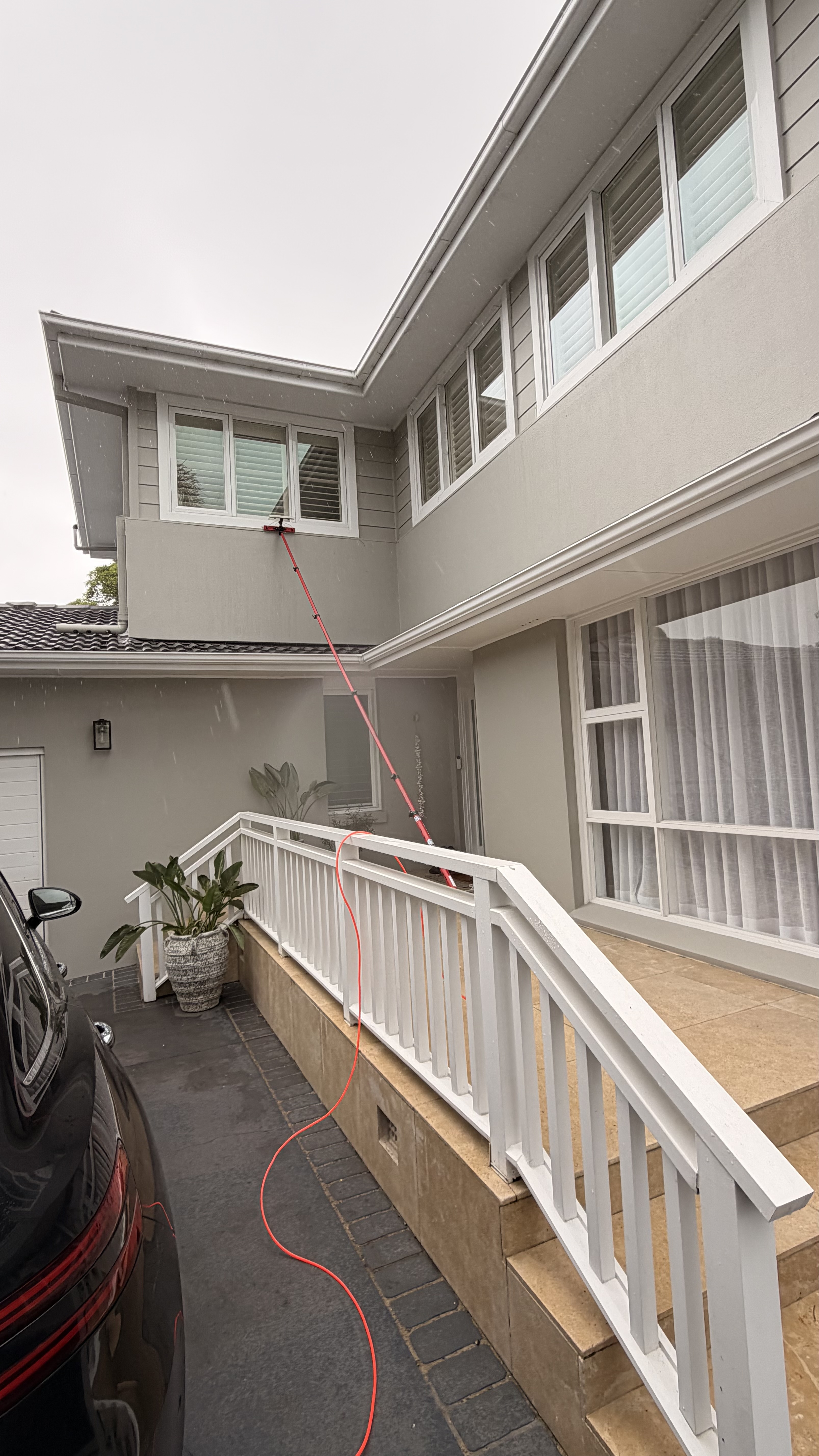 Water-fed pole window cleaning on white house Northern Beaches